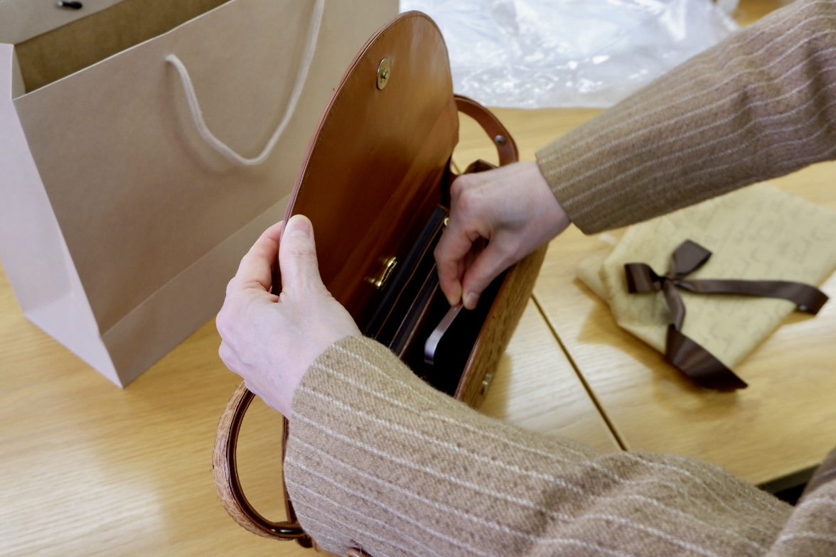 バッグに優しく語りかけながら携帯を入れる様子